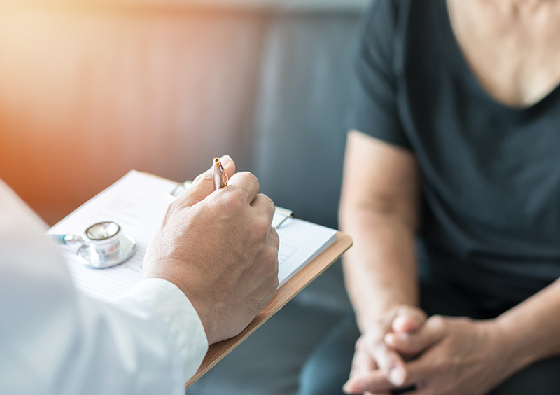 Geriatric doctor (geriatrician) consulting and diagnostic examining elderly senior adult patient (older person) on aging and mental health care in medical clinic office or hospital examination room